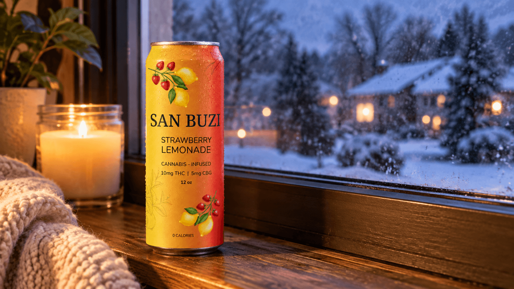 A can of San Buzi Strawberry Lemonade on a windowsill with a lit candle, overlooking snow falling outside